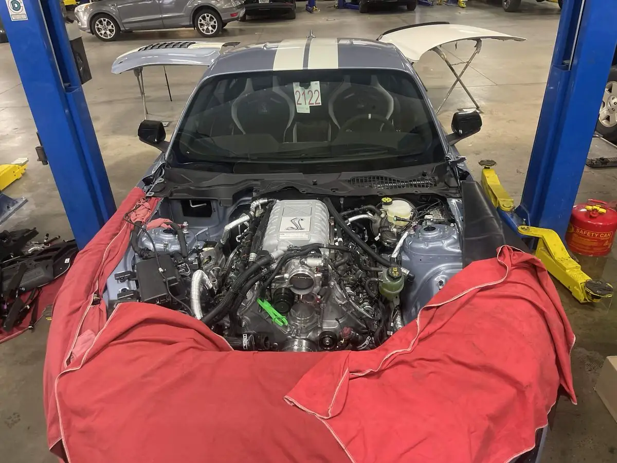 Supercharged Shelby GT500 engine bay opened for service with the fenders covered